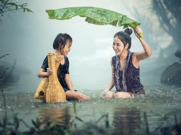 une mere et sa fille sous la pluie dans l'eau