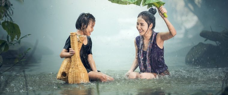 une mere et sa fille sous la pluie dans l'eau